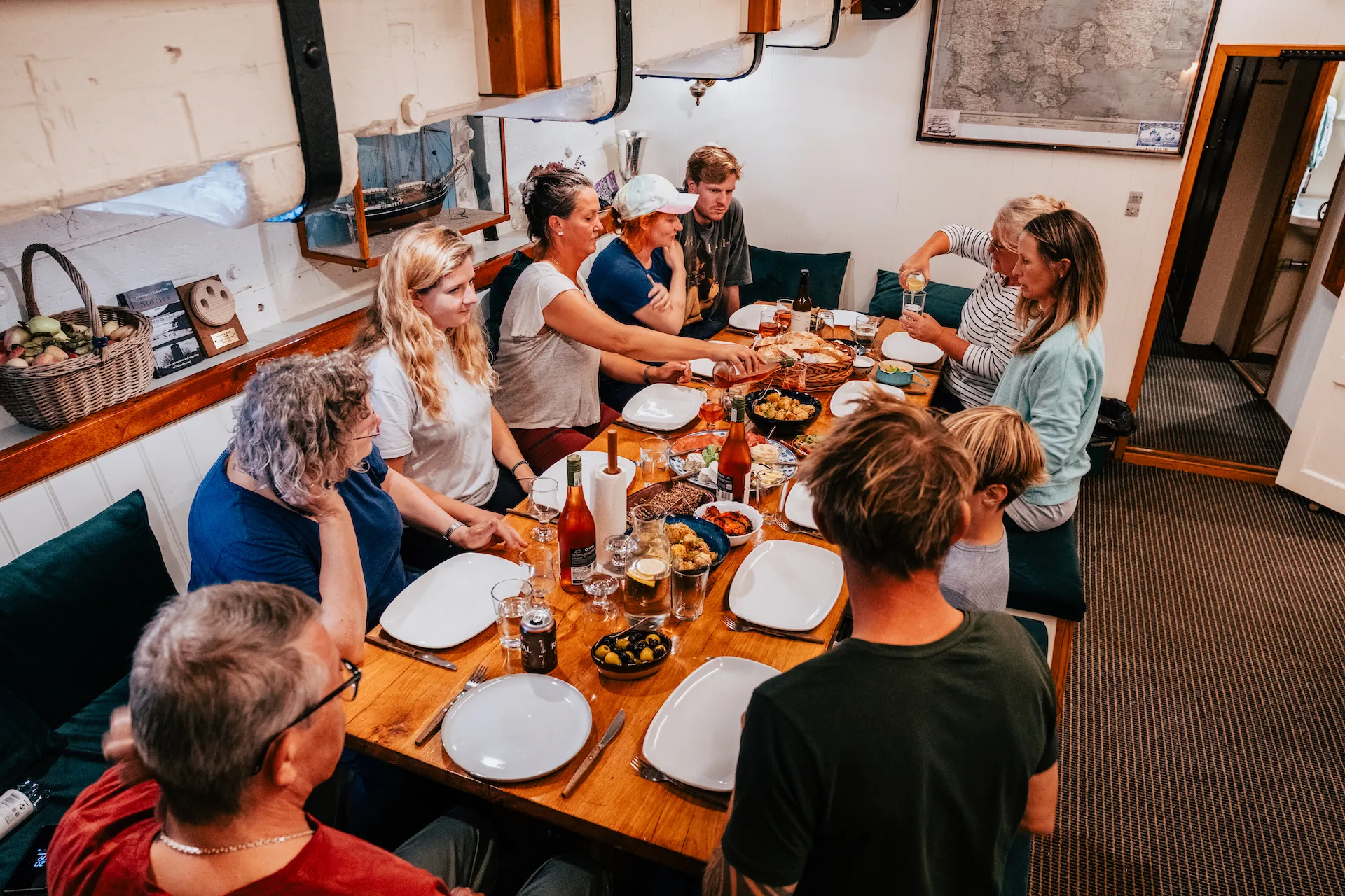 Guests share dinner around the saloon table