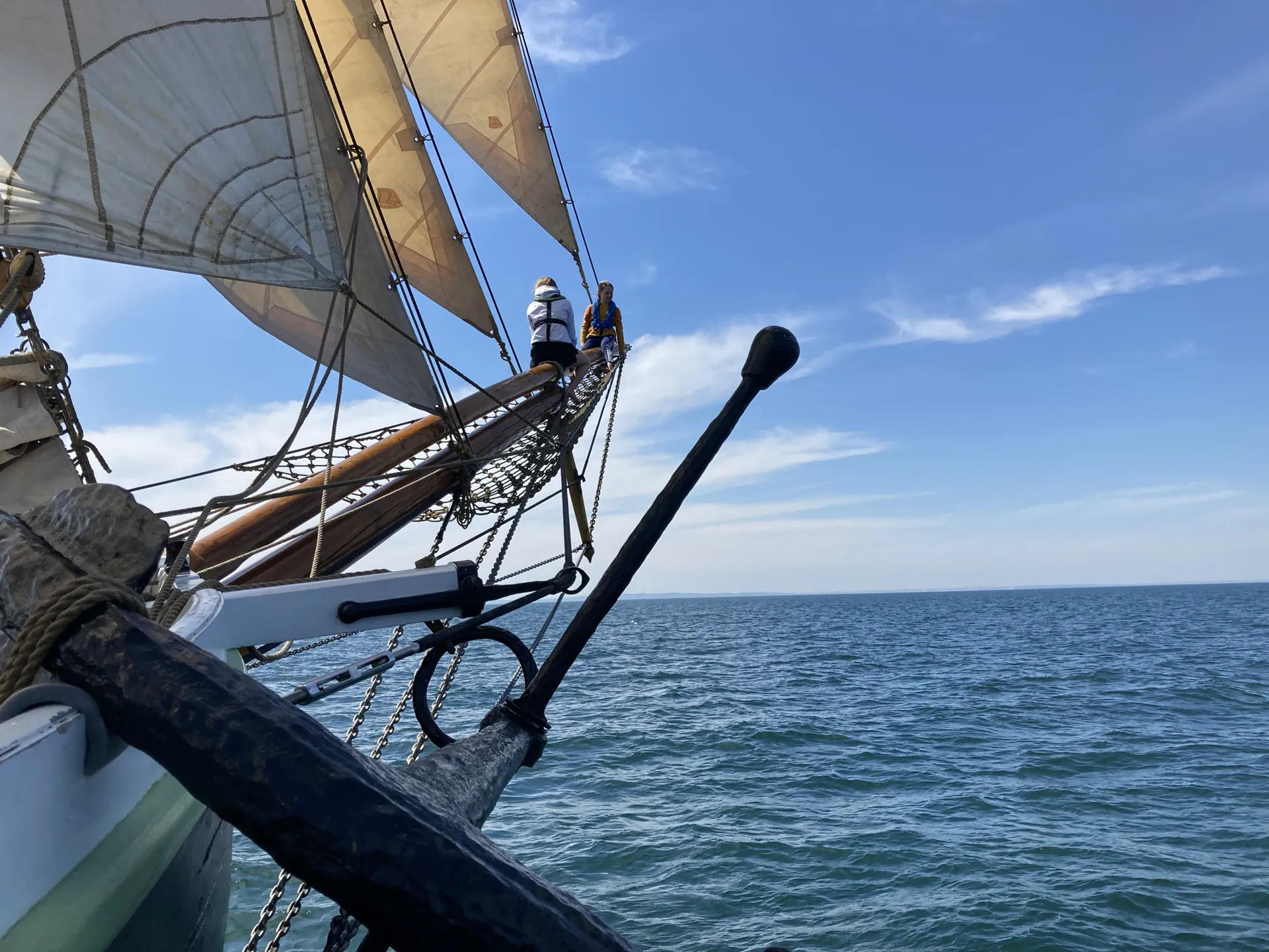 Guests sitting in the bowsprit net above the water
