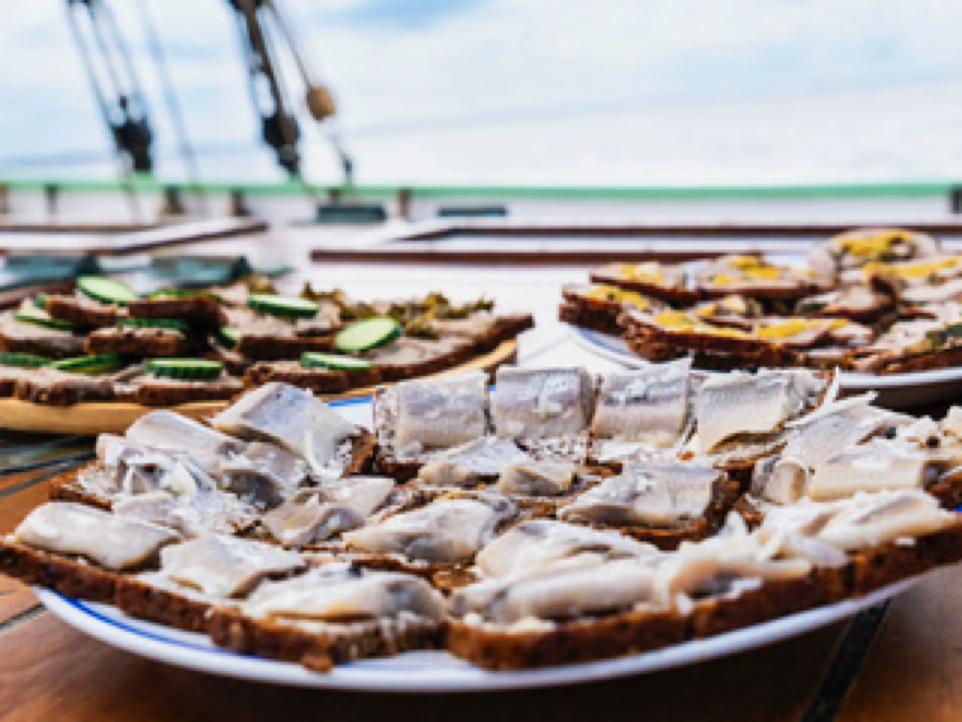Herring on rye bread served on plates on Aron's deck